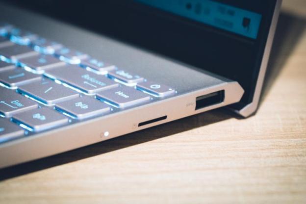 An open computer sitting on top of a wooden table

Description automatically generated